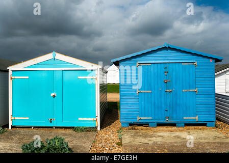 Cabines de plage bleue sous un ciel dramatique à St Leonards on Sea à Hastings, East Sussex Banque D'Images