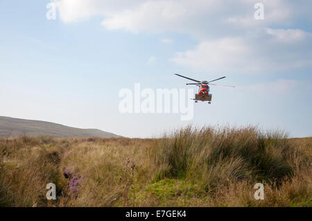 Garde-côtes irlandais IRCG Garda Cósta na hÉireann Sikorsky hélicoptère vole au-dessus lors d'un sauvetage médical en Irlande rurale, comté de Donegal. Banque D'Images