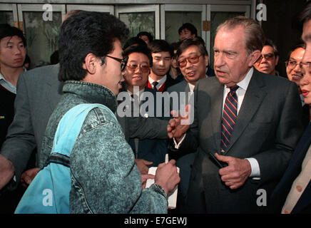 L'ancien Président des États-Unis, Richard M. Nixon parle avec un étudiant comme une foule se rassemble au cours d'une balade autour du quartier commerçant de Wangfujing Street, 30 octobre 1989 à Beijing, Chine. Nixon s'est rendu à titre privé par le gouvernement chinois. Banque D'Images