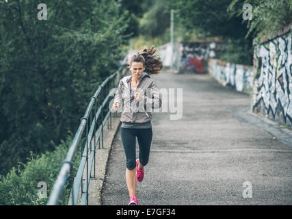 Jeune femme Fitness jogging dans le parc de la ville Banque D'Images