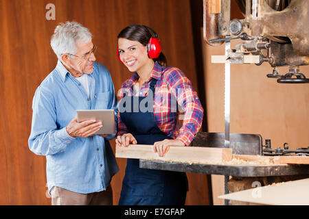 Carpenter avec des collègue using digital tablet Banque D'Images