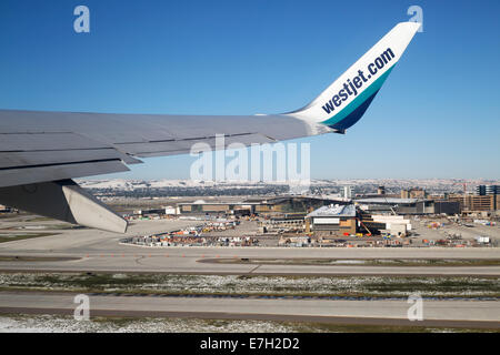 Avion WestJet survolant l'aéroport de Calgary après le décollage Banque D'Images