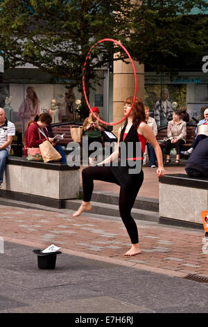 Une jolie jeune femme danse avec son cerceau dans le centre-ville de Dundee sur un matin de septembre chaud, UK Banque D'Images