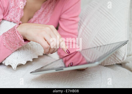 La femme de toucher du doigt de l'écran de l'appareil mobile et de choisir quelque chose dans la boutique Internet ou réseau social Banque D'Images