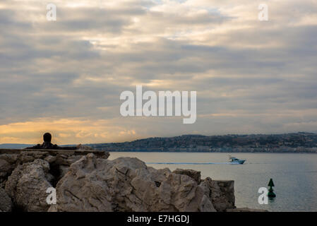 Montres homme solitaire le coucher de soleil sur la Baie des Anges à Nice, France Banque D'Images