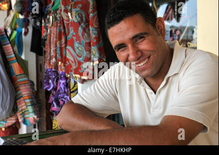 Portrait homme égyptien se détendre et sourire devant des foulards qu'il vend en boutique, Egypte Banque D'Images