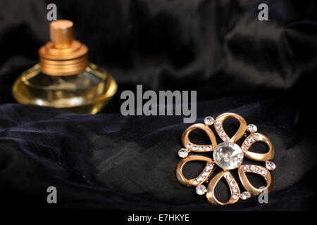 Bijoux élégant avec des brillants et du parfum sur la soie noire Banque D'Images