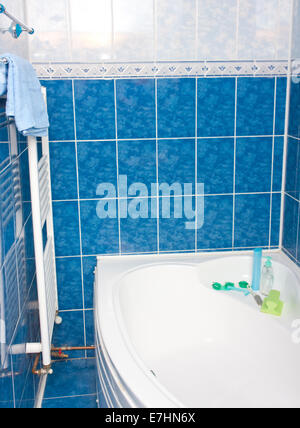 Salle de bains moderne avec baignoire, carreaux bleu et le radiateur Banque D'Images