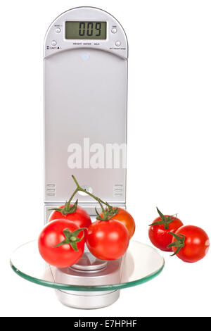 Tomates cerise sur balance de cuisine électronique isolé sur fond blanc Banque D'Images