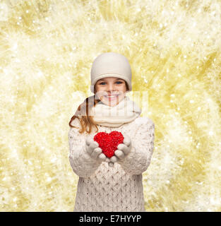 Dreaming girl in winter clothes avec coeur rouge Banque D'Images