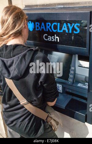 Une femme à l'aide d'un distributeur automatique de Barclays cash machine à Alnwick Northumberland Royaume-uni Banque D'Images