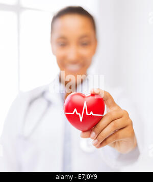 Female doctor holding red heart avec ligne ecg Banque D'Images