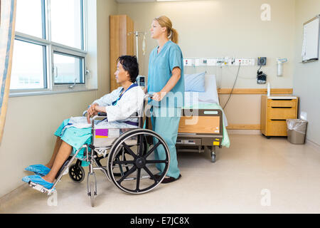 Nurse with patient assis sur la chaise de roue à fenêtre de l'hôpital Banque D'Images