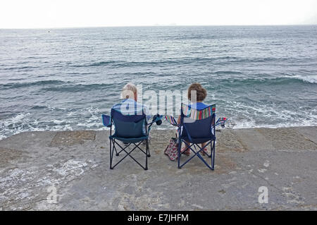 Un couple s'asseoir près de la mer à Falmouth, Cornwall Banque D'Images