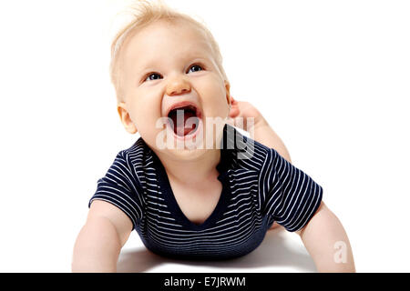 Heureux bébé couché sur le sol blanc et en haut. Isolé sur fond blanc. Banque D'Images