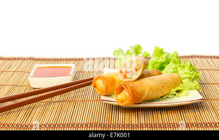 Rouleaux de printemps frits dans un plat servi avec sauce chili contre fond blanc Banque D'Images