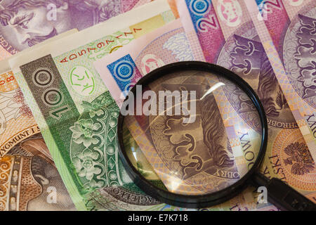 La fausse monnaie concept. Polish zloty Billets Monnaie et loupe Banque D'Images