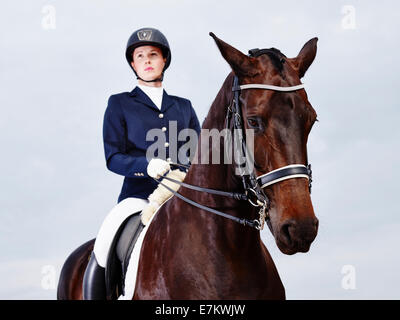 Cheval brun et belle femme portant des vêtements d'équitation - focus on horse Banque D'Images