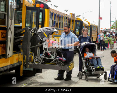 Un chauffeur d'autobus scolaire utilise un ascenseur hydraulique pour un élève handicapé au cours d'une visite de classe pour le Coney Island amusement park à Brooklyn, New York. Banque D'Images