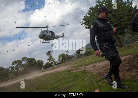 San Juan Sacatepequez, Guatemala. Sep 20, 2014. Un agent de la Police nationale du Guatemala garde le site où une série de violences ont eu lieu, à Los Pajoques village, San Juan Sacatepequez Municipalité, Sacatepequez, Guatemala, du ministère le 20 septembre 2014. Au moins six personnes sont mortes dans une communauté locale dans le département central, Sacatepequez, Guatemala, au cours d'une série de violences dans lequel quatre maisons bois et carton et sept véhicules ont été incendiés. © Luis Echeverria/Xinhua/Alamy Live News Banque D'Images