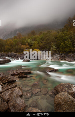 Jour de pluie dans la vallée de Romsdalen Møre et Romsdal, la Norvège. La rivière Rauma est au premier plan, et c'est célèbre pour son excellente pêche au saumon. Banque D'Images