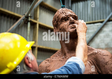 Colin Caffell, un sculpteur travaillant sur l'exploitation minière de l'étain sculpture son mémorial. Banque D'Images