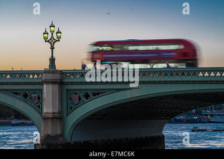 Un bus de Londres rouge à travers le pont de Westminster dans le crépuscule d'été. Banque D'Images