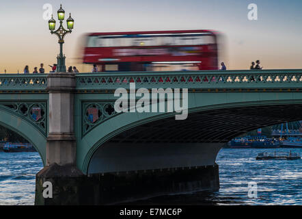 Un bus de Londres rouge à travers le pont de Westminster dans le crépuscule d'été. Banque D'Images