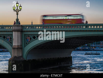 Un bus de Londres rouge à travers le pont de Westminster dans le crépuscule d'été. Banque D'Images