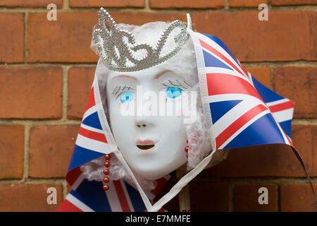 Plastique blanc peint masque de visage avec Tiara et drapeaux Union jack d'un mur de briques Banque D'Images