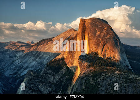 Le dernier soir de la lumière sur les murs de granit de demi-dôme comme thunderheads construire sur le Parc National de Yosemite en Californie. Banque D'Images