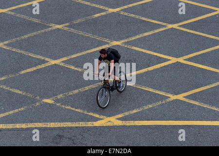 Un cycliste dans une zone jaune junction. Banque D'Images