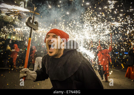 Un démon crie alors qu'il déclenche son pétards en dansant dans la rue pendant la Merce 2014. Sep 21, 2014. Diverses associations de danse (Correfocs démons) de Barcelone se sont réunis pour compenser leurs pétards parmi une foule massive des citoyens et des touristes à la suite des spectacles de feu et de fumée, de bruit au cours pour enfants et adultes au cours de la Merce 2014 Credit : Matthias Rickenbach/ZUMA/ZUMAPRESS.com/Alamy fil Live News Banque D'Images