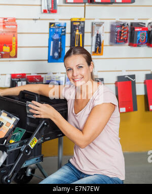 Femme l'achat d'outils in hardware store Banque D'Images