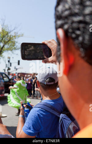 L'homme la capture vidéo de l'événement à un festival en plein air avec smart phone - USA Banque D'Images