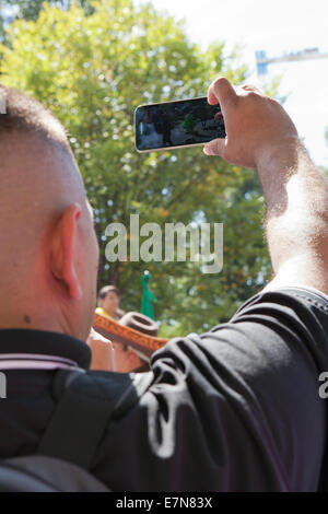 L'homme la capture vidéo de l'événement à un festival en plein air avec smart phone - USA Banque D'Images