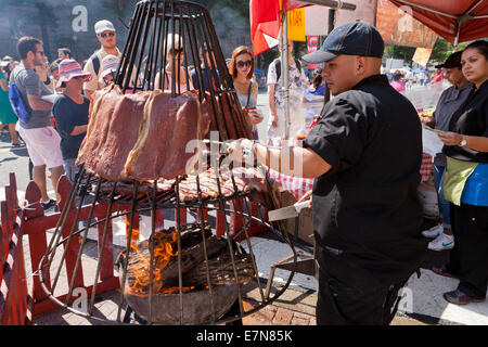 La cuisson des steaks de boeuf de l'homme sur un grand barbecue - USA Banque D'Images