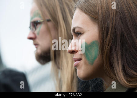 Oslo, Norvège. Sep 21, 2014. Une femme et met avec cœurs verts peints sur leurs visages rejoignez des milliers marche dans le centre-ville d'Oslo, Norvège, pour appuyer l'action sur le changement climatique mondial, le 21 septembre 2014. Selon les organisateurs de 'la', mars climatique la démonstration d'Oslo a été l'un des événements de solidarité 2 808 dans 166 pays, qui était "le plus grand de l'histoire mars climatique'. Credit : Ryan Rodrick Beiler/Alamy Live News Banque D'Images