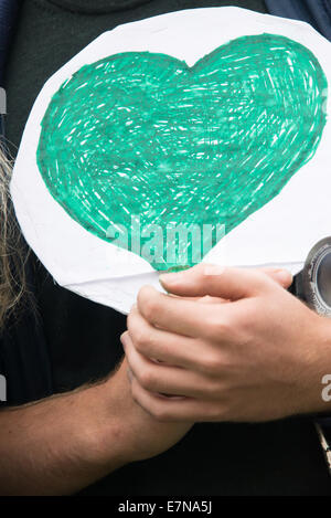 Oslo, Norvège. Sep 21, 2014. Un jeune homme porte un coeur vert comme des milliers de manifestants dans le centre-ville d'Oslo, Norvège, pour appuyer l'action sur le changement climatique mondial, le 21 septembre 2014. Selon les organisateurs de 'la', mars climatique la démonstration d'Oslo a été l'un des événements de solidarité 2 808 dans 166 pays, qui était "le plus grand de l'histoire mars climatique'. Credit : Ryan Rodrick Beiler/Alamy Live News Banque D'Images