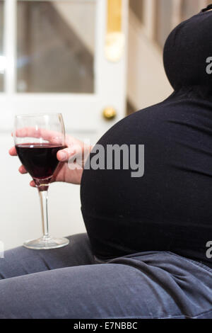 Pregnant woman holding a glass of wine Banque D'Images