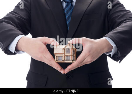Businessman holding house model Banque D'Images