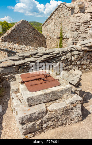 Puits en pierre dans village déserté Humac, île de Hvar, Croatie Banque D'Images