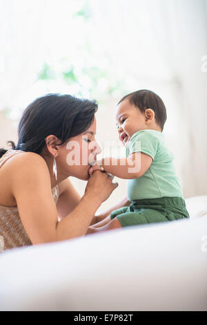 Mère embrassant la main de son bébé (6-11 mois) Banque D'Images