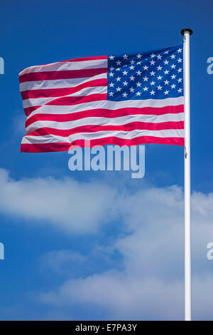 Stars and Stripes / drapeau national nord-américain des USA sur un mât au vent contre ciel nuageux Banque D'Images