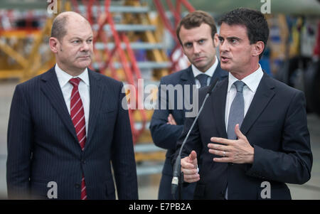 Hambourg, Allemagne. 22 Sep, 2014. Le Premier ministre français Manuel Valls (R) est titulaire d'un pres conférence en présence du maire de Hambourg l'Olaf Scholz (L) et ministre de l'économie, le renouveau industriel et la technologie de l'information Emmanuel Macron (C) lors d'une visite de l'usine d'Airbus à Hambourg, Allemagne, 22 septembre 2014. Le Premier ministre français, Valls et ministre de l'économie Macron visité Hambourg. Photo : AXEL HEIMKEN/DPA/Alamy Live News Banque D'Images