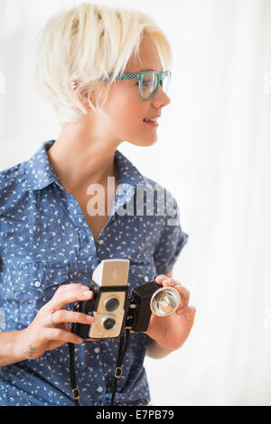 Woman holding vintage camera Banque D'Images