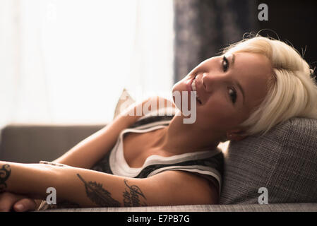 Portrait of blonde woman relaxing on sofa Banque D'Images