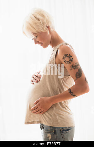 Femme enceinte avec les mains sur l'estomac Banque D'Images