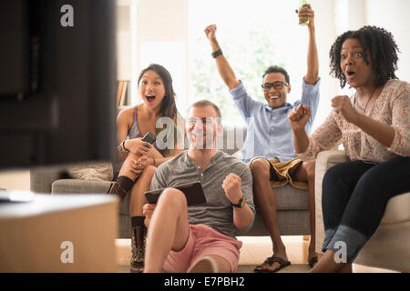 Groupe d'amis, regarder la télévision Banque D'Images