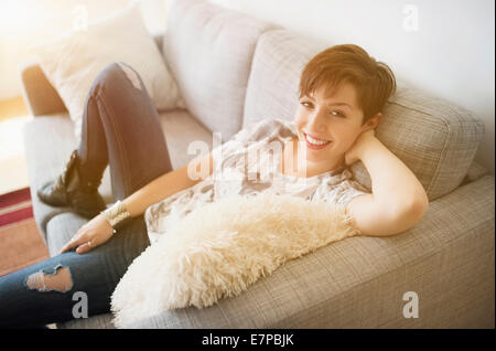 Portrait of smiling woman sitting on sofa Banque D'Images